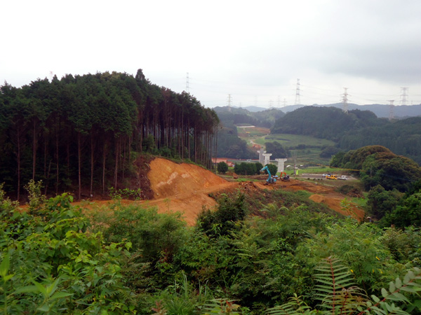 平成24年7月(木を切っていたところの土を削り始めました。削った土は他の場所で土を盛るために再利用され、道路の形状を作っていきます。)