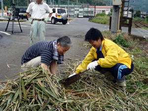 「花植え体験」藁を細かくして